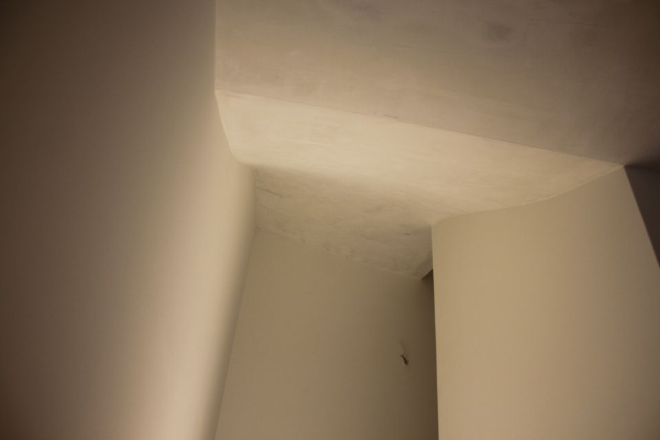 Innenecke mit weissen Wänden, Decke und baulichem Element.