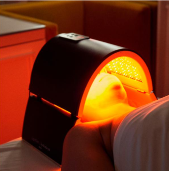 Persona sometida a terapia de luz roja con un dispositivo facial.