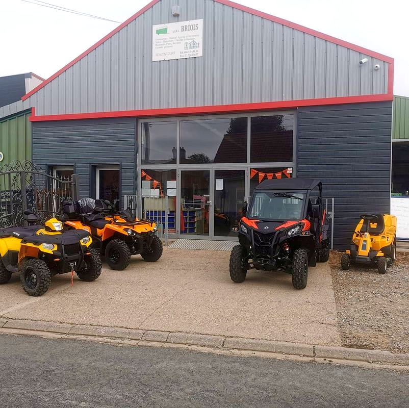 Quads orange et noirs garés devant un bâtiment gris