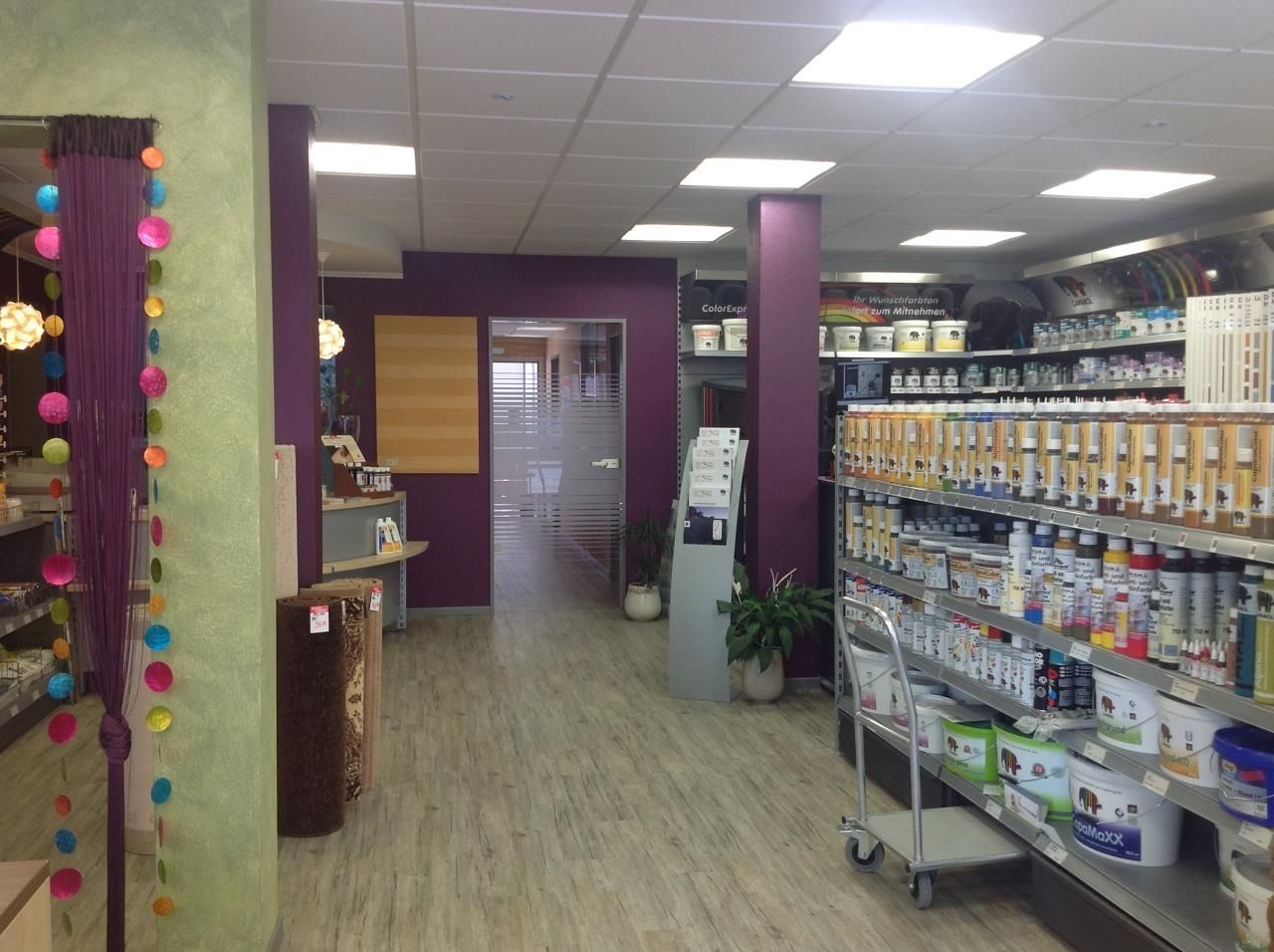Ein Geschäft mit lila Wänden und Regalen voller Farbe