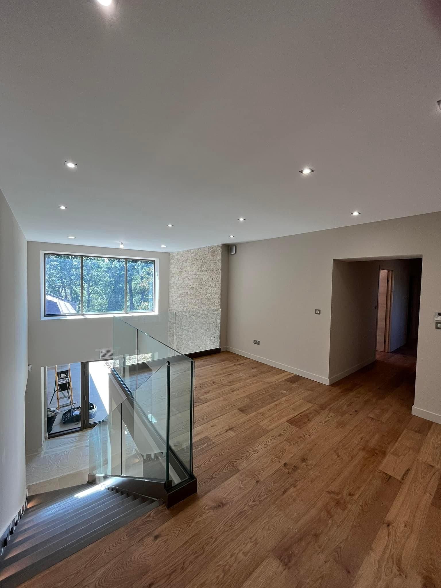 Étage avec un sol en parquet et un garde corps en verre