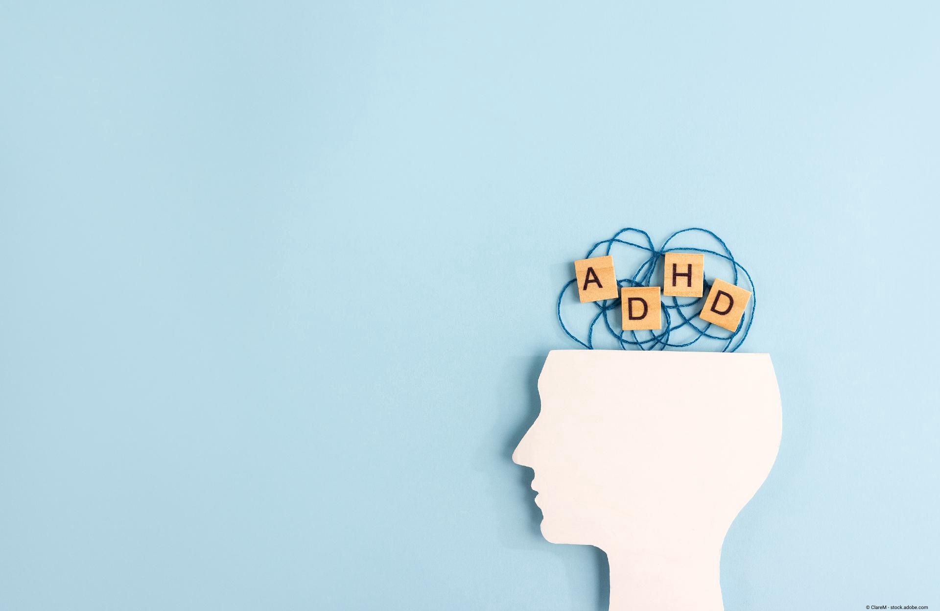 Silhouette eines menschlichen Kopfes und Holzklötze mit den Buchstaben ADHS auf pastellfarbenem Hint