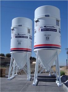 Dos silos blancos con una franja roja y azul en el costado están uno al lado del otro.