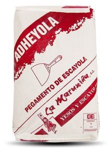 Una bolsa de adheyola reposa sobre una superficie blanca.