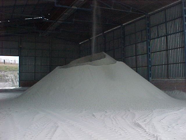 Una gran pila de arena blanca en un almacén.