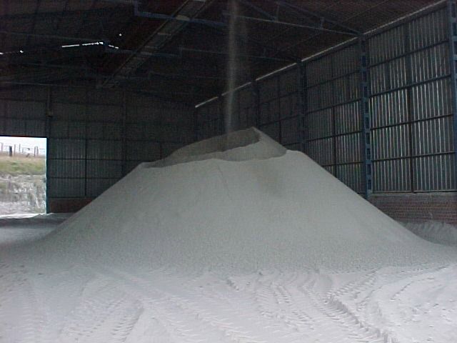 Una gran pila de arena blanca en un almacén.