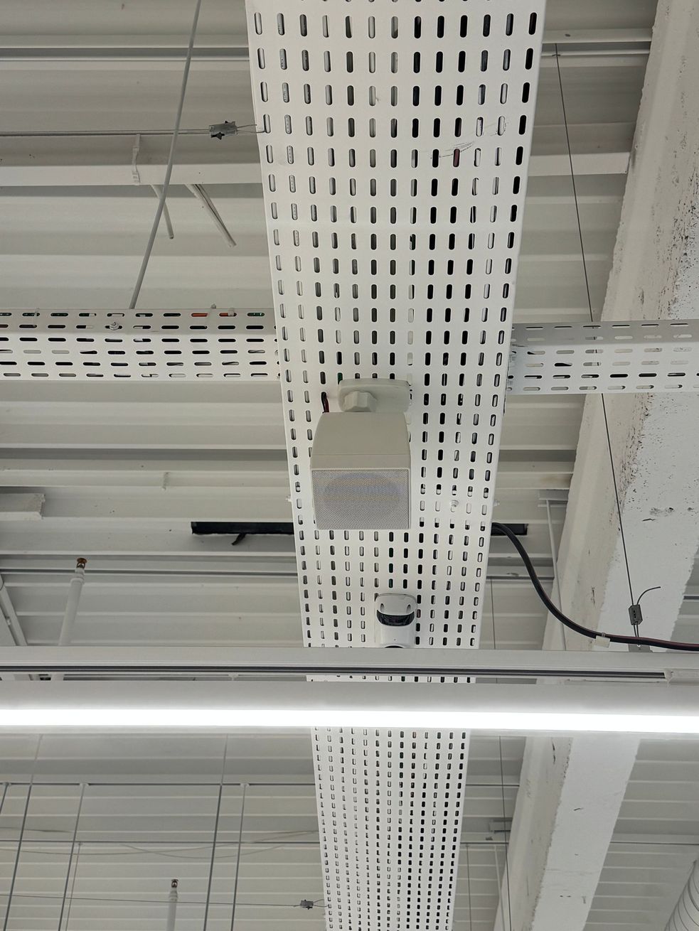 Intérieur du magasin avec éclairage blanc au plafond. 