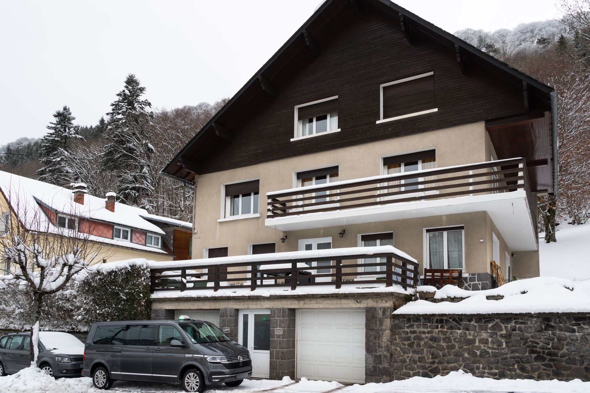 Taxi van garé devant un chalet enneigé