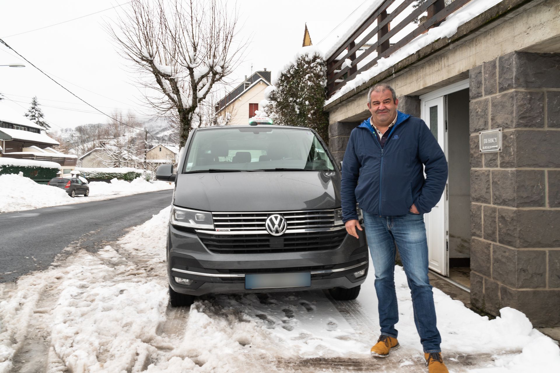 Monsieur Hublin devant son véhicule 9 places dans la neige