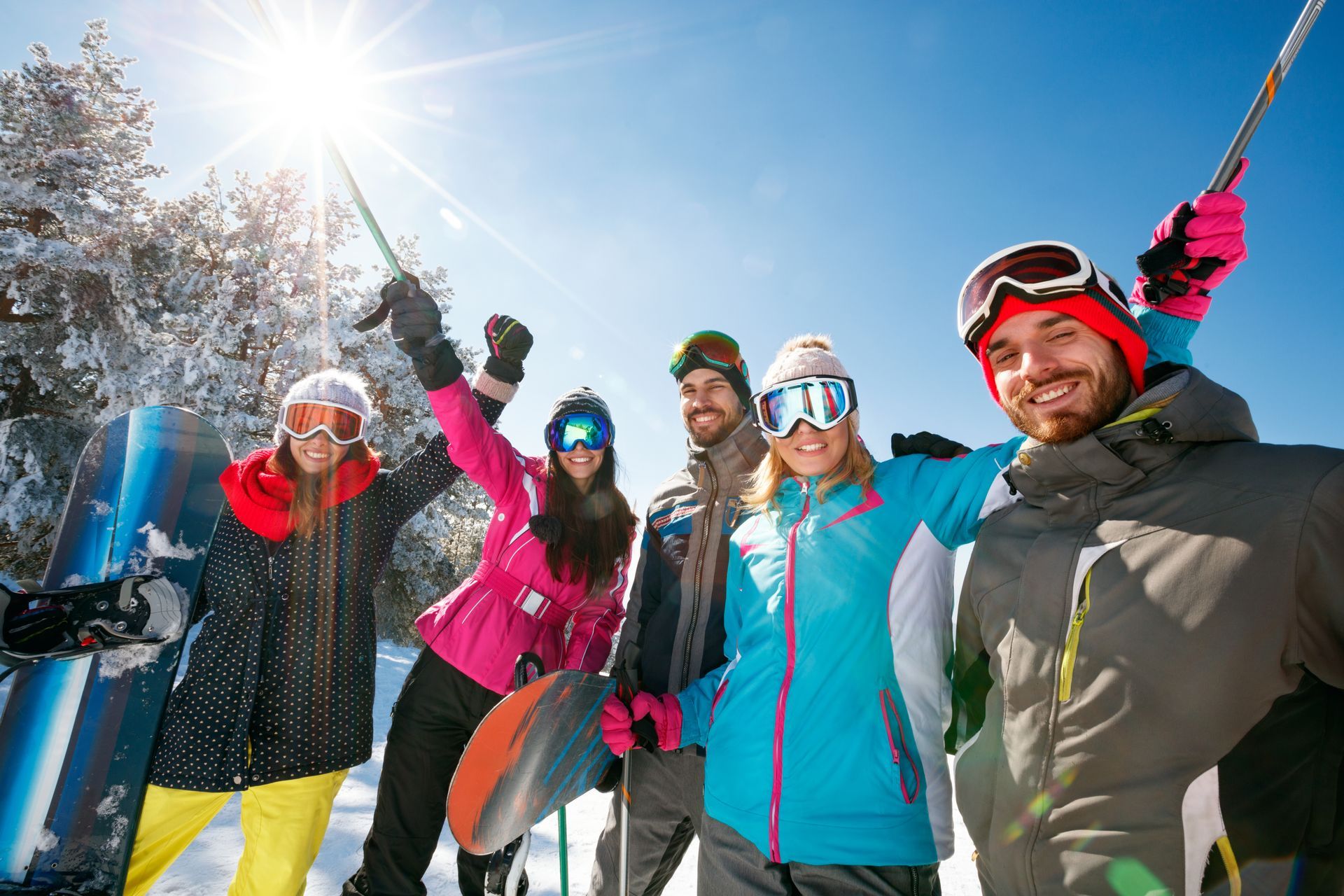 Un groupe d'amis en tenue de ski colorée sourient dans la neige