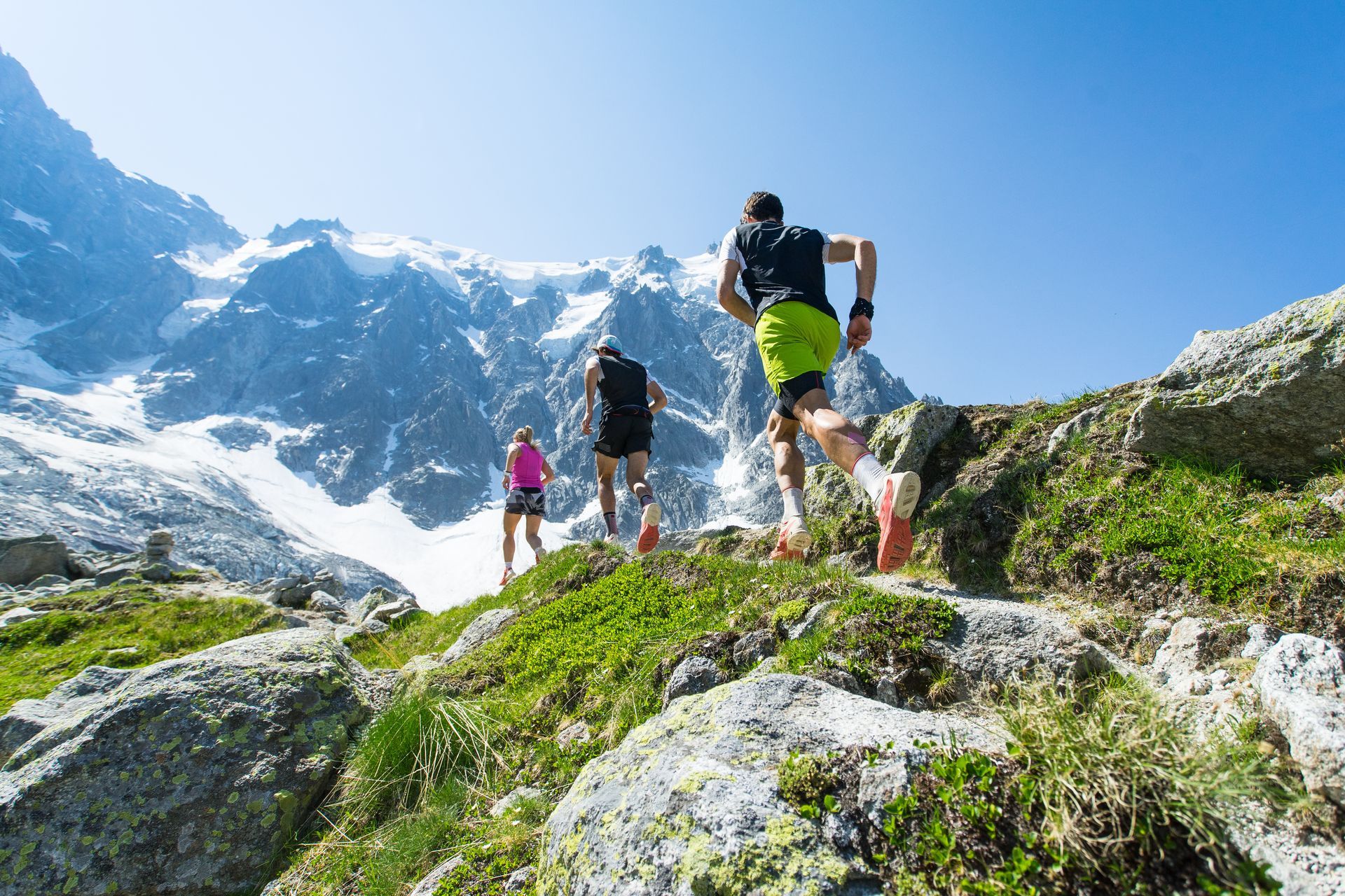 Un groupe de trois personnes fait du trail en montagne