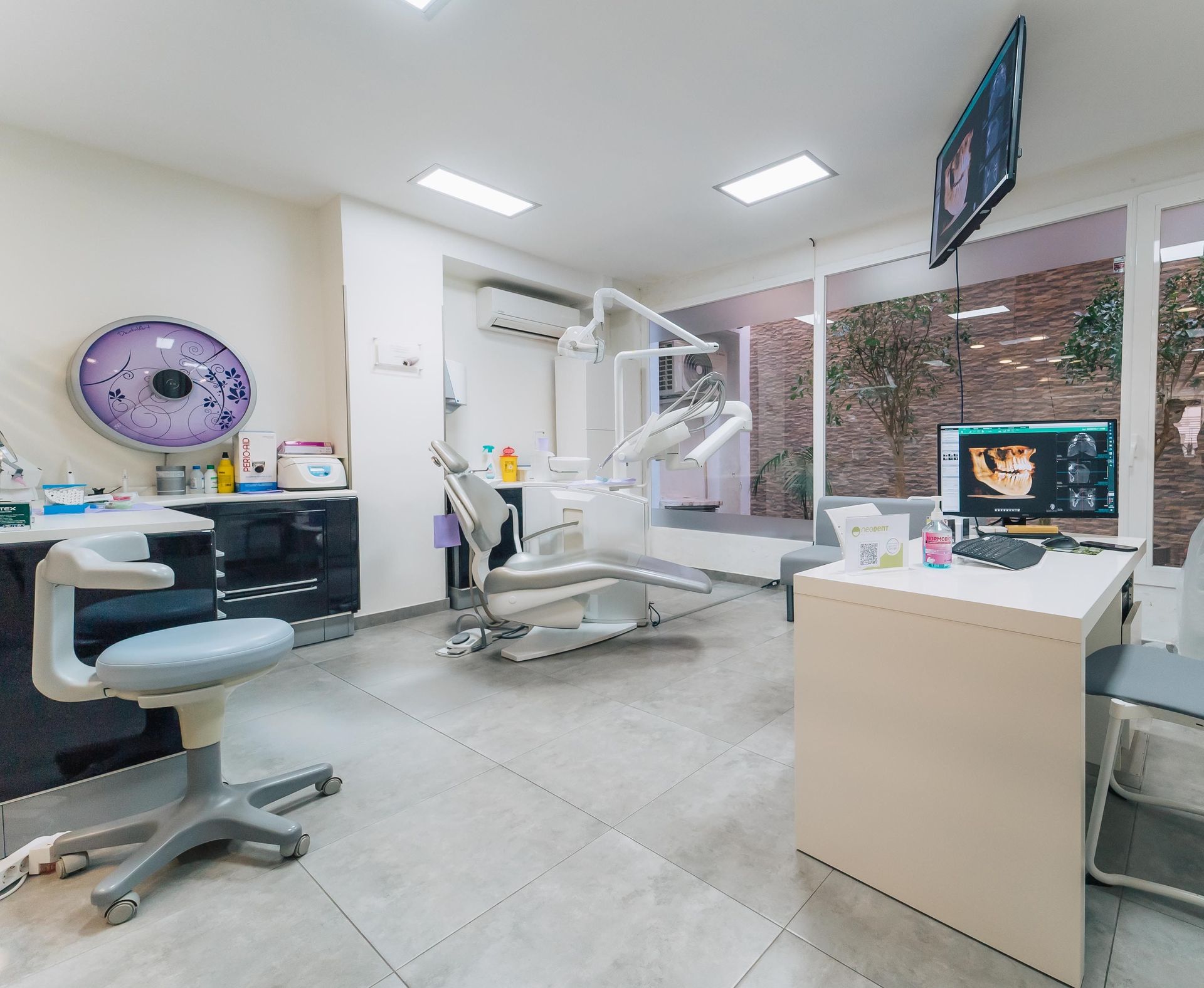 Un consultorio dental con una silla dental y un escritorio.