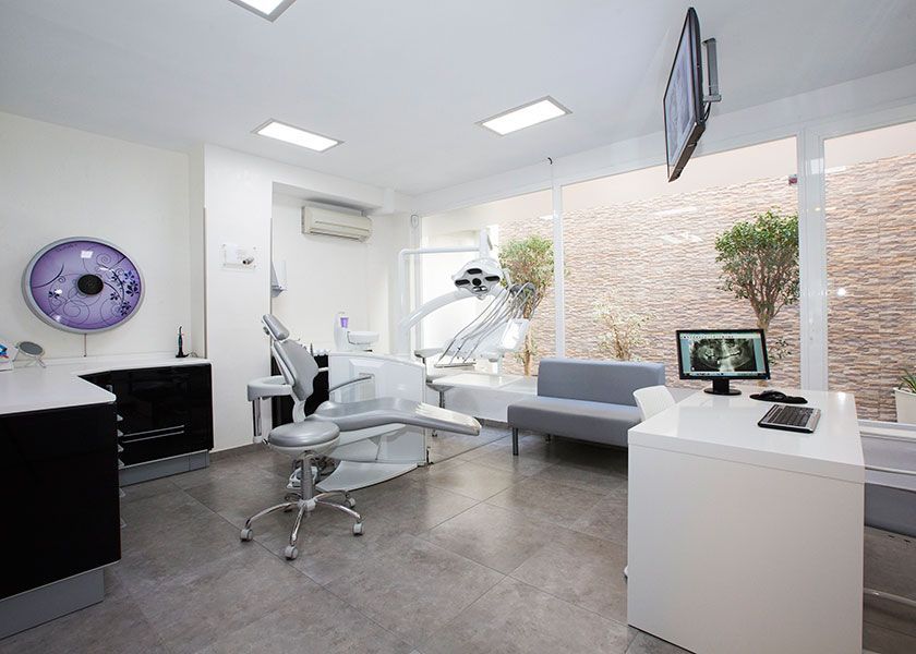 Un consultorio dental con un sillón dental y un sofá.