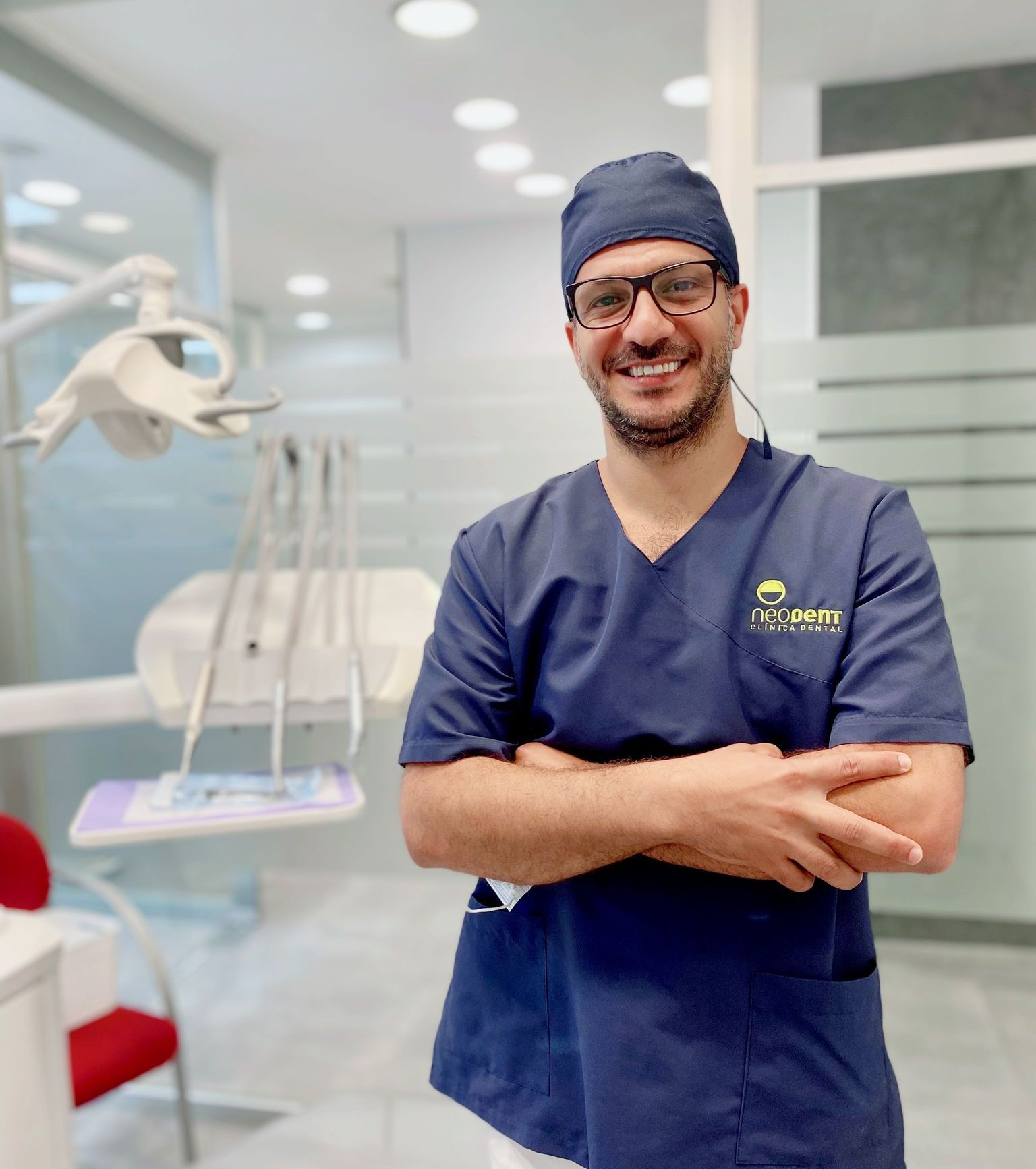 Un hombre en un consultorio dental con los brazos cruzados.