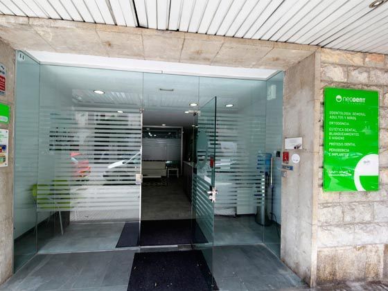 La entrada a un edificio con un cartel verde en la pared.