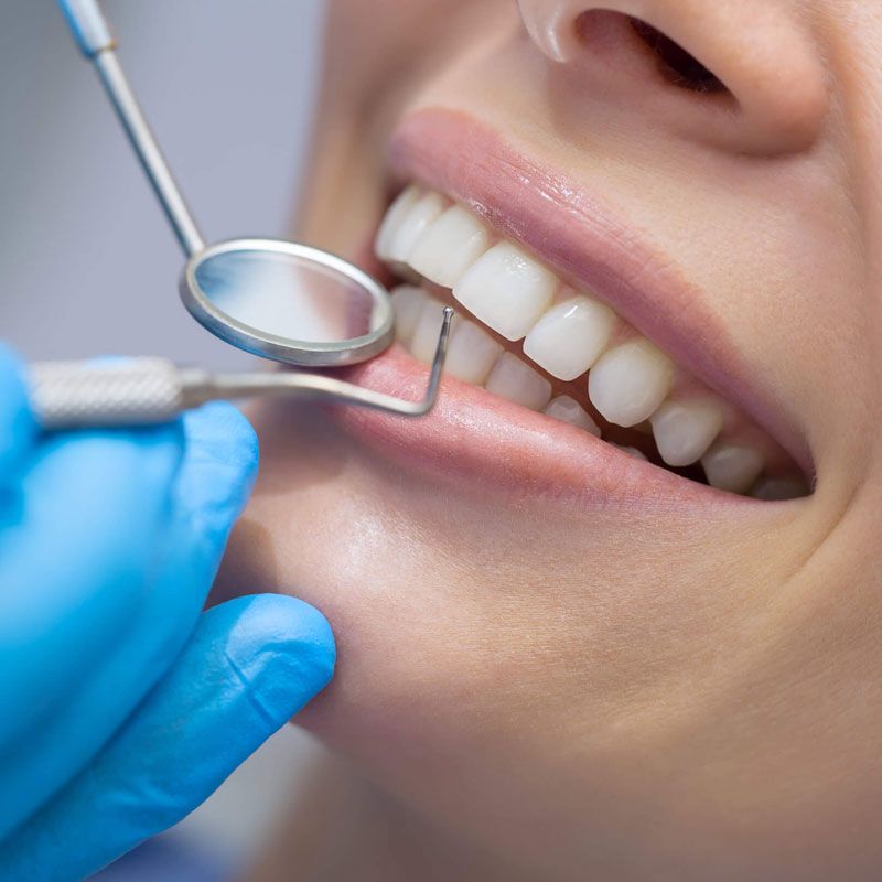 Una mujer está siendo examinada por un dentista.