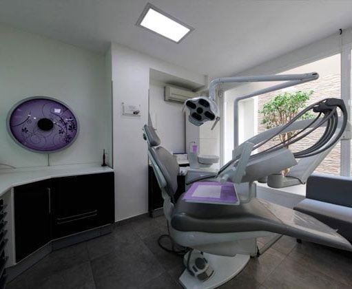 Un consultorio dental con un sillón dental y un reloj en la pared.