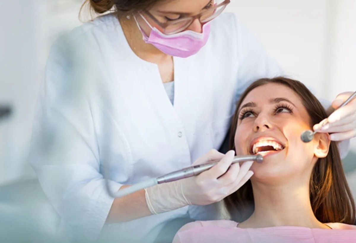 Una mujer está siendo examinada por un dentista.