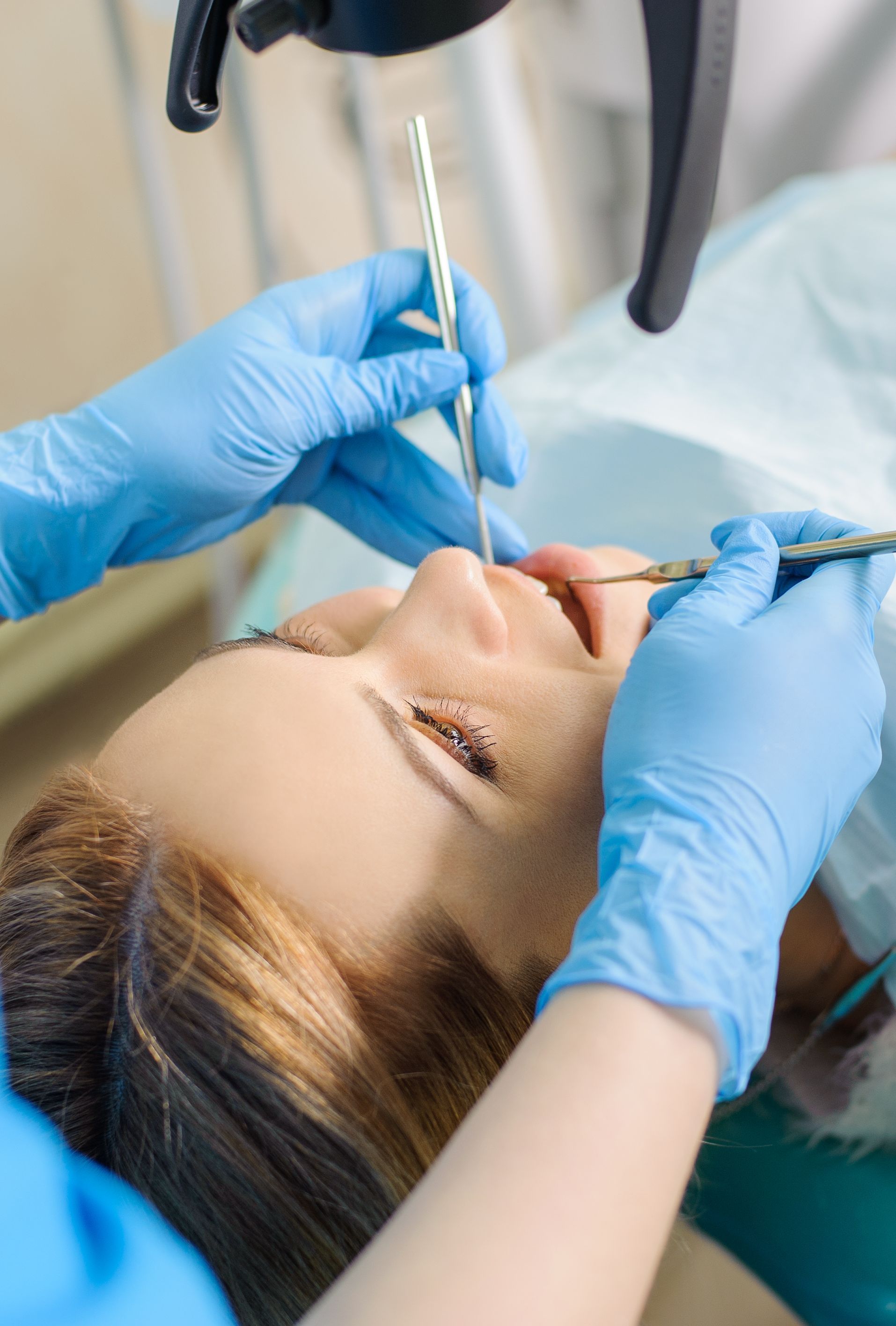 Una mujer está siendo examinada por un dentista.