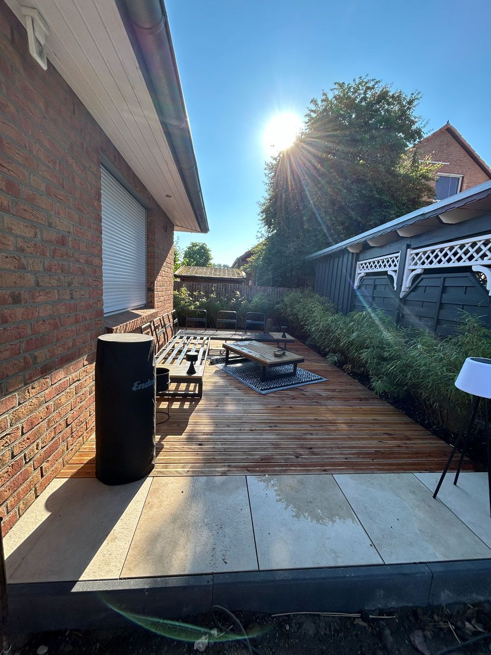 Ein Backsteinhaus mit einer Holzterrasse davor.