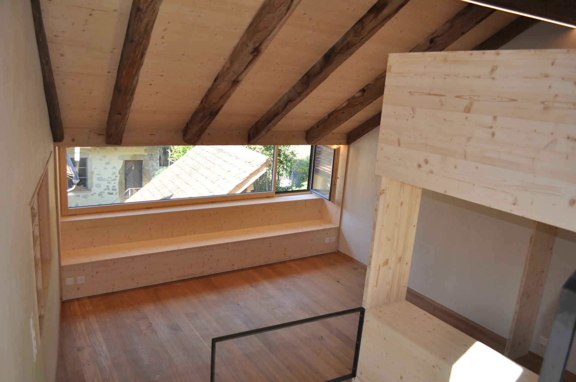 Plafond en bois au-dessus d'un couloir avec escalier, portes et éclairage encastré.