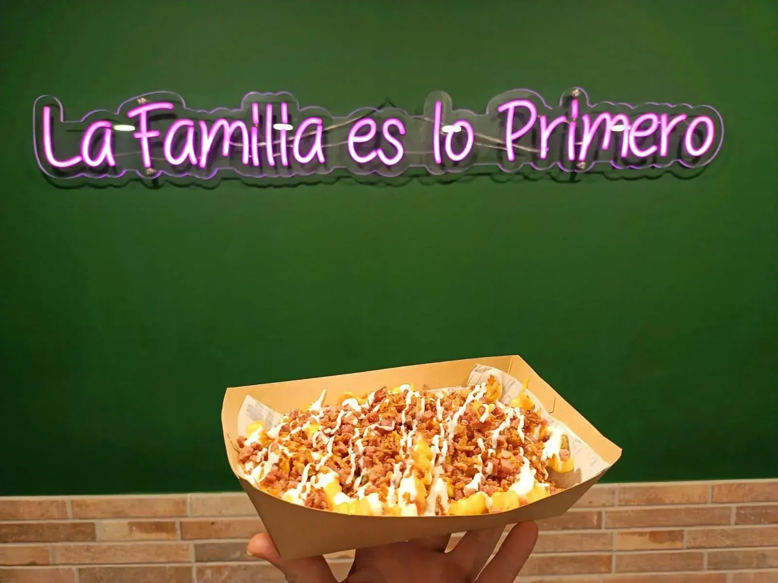 Pan tostado cubierto con rodajas de tomate y aguacate, sobre un plato con condimentos.