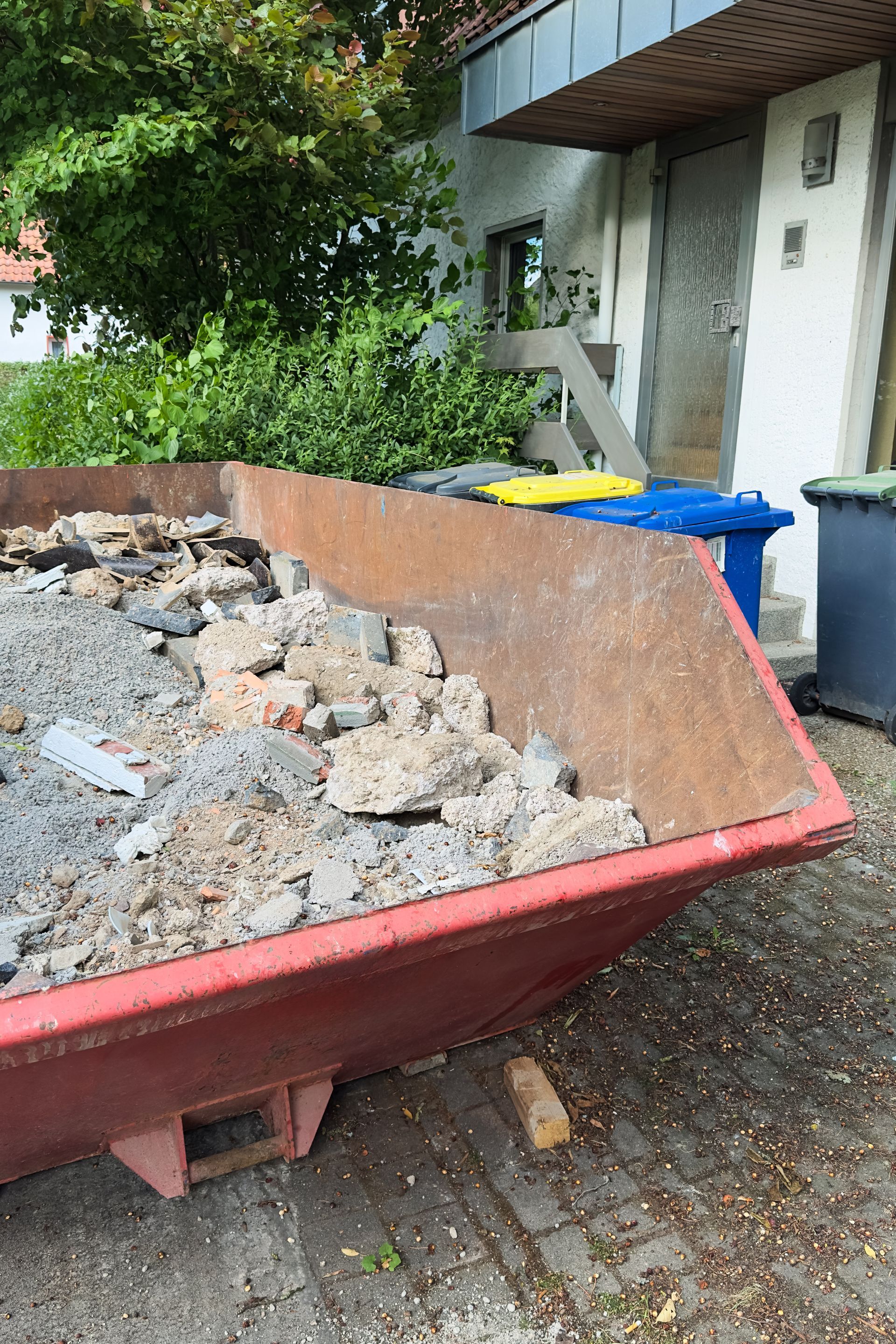 Des gravats dans une benne proche de la maison