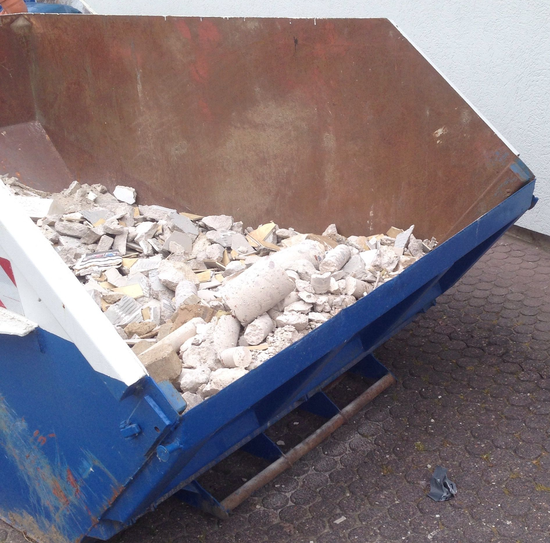 Une benne de couleur bleue contenant des gravats