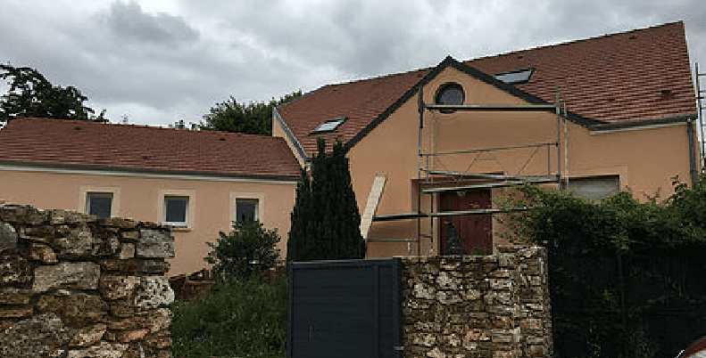 Maison avec muret en pierre et échafaudage