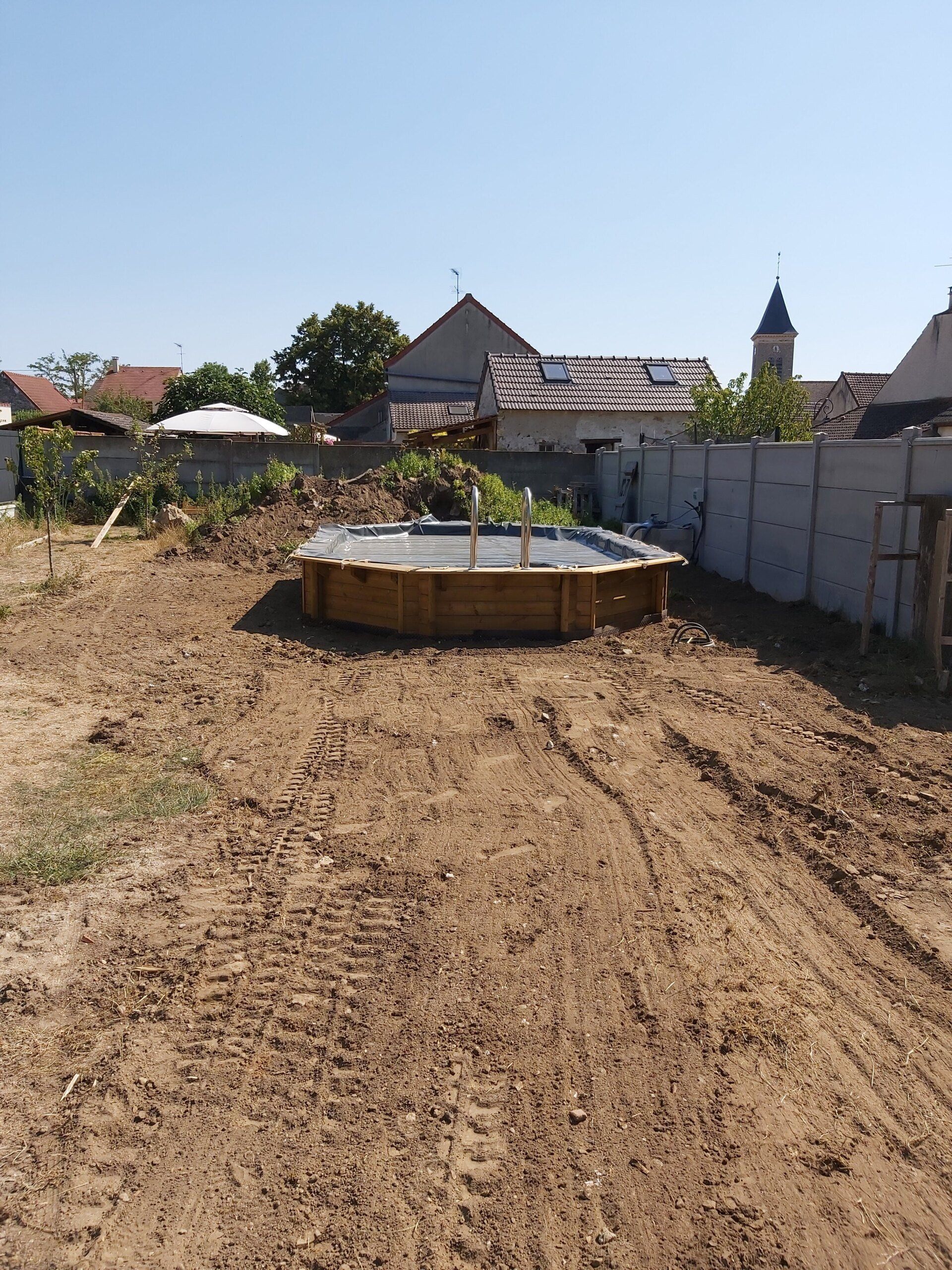 Piscine en bois semi-enterrée au fond d'un terrain