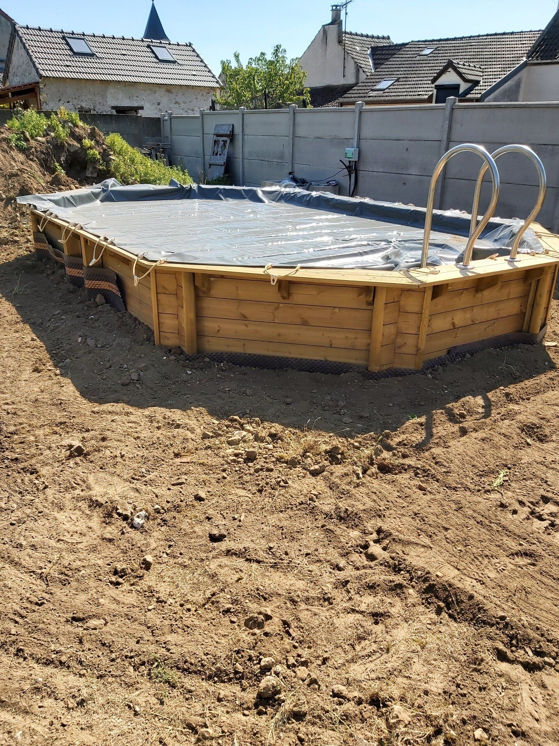 Piscine en bois semi-enterrée avec bâche de protection