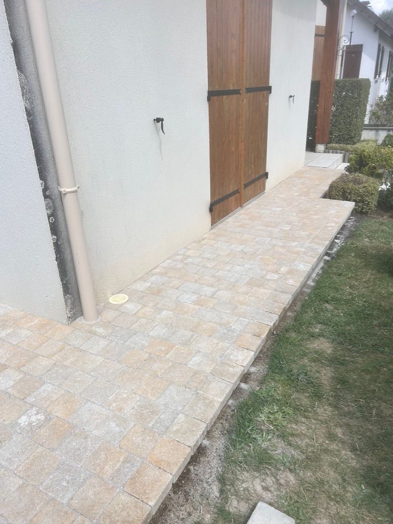 Passage piéton en pavés le long d'une maison