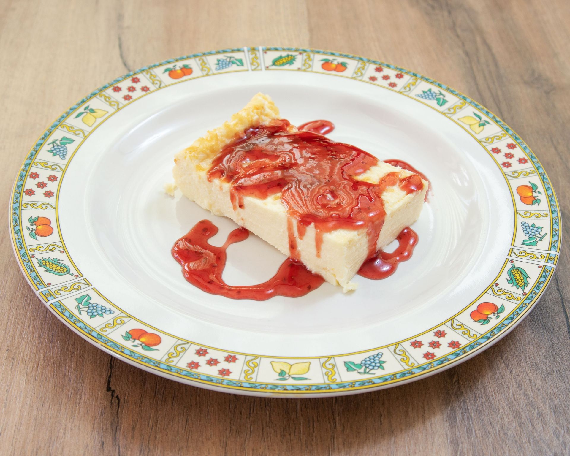 Un trozo de tarta de queso con salsa de fresa en un plato