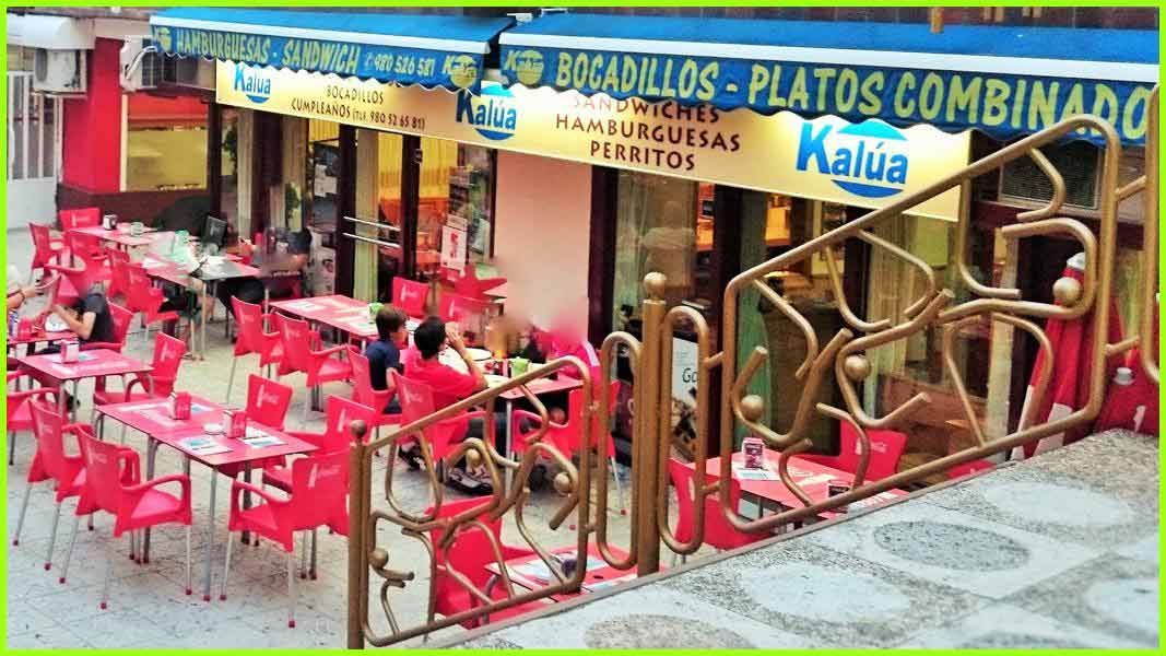 Un restaurante con mesas y sillas delante.