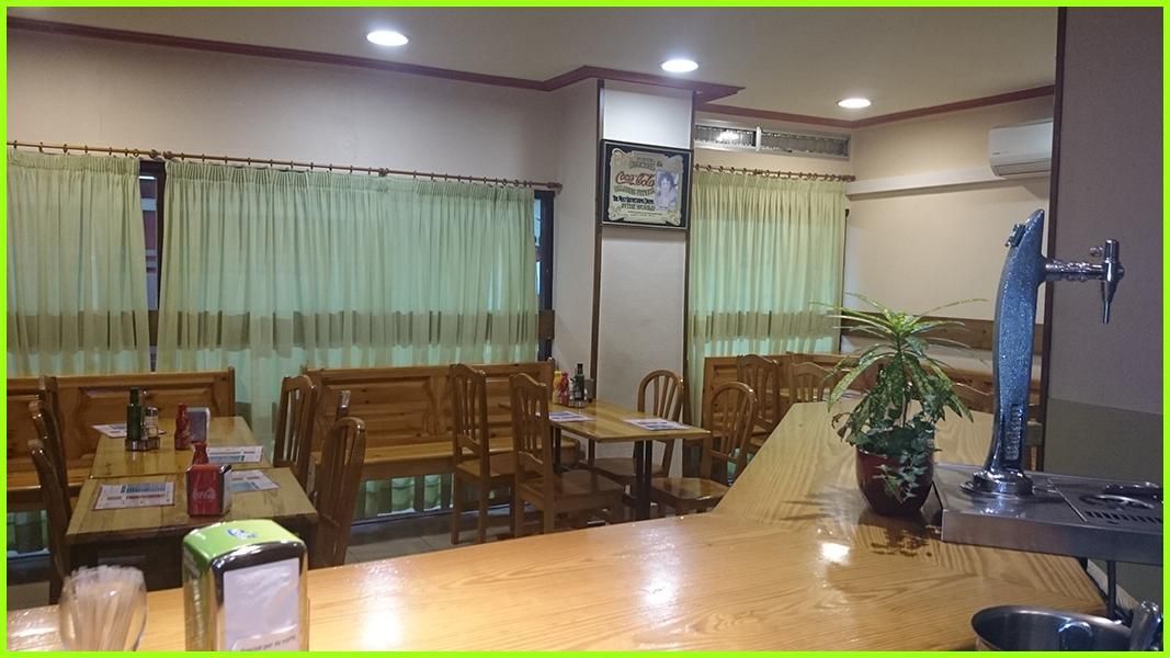 Un restaurante con mesas y sillas y un reloj en la pared.