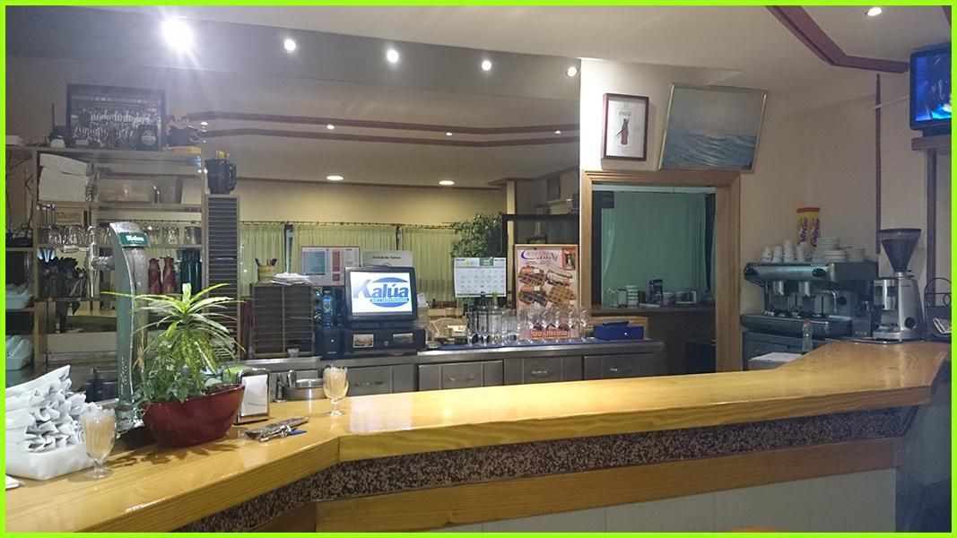 Un restaurante con un gran mostrador de madera y un reloj en la pared.