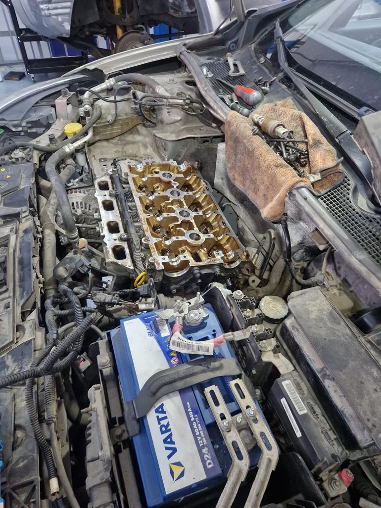 Se está trabajando en el motor de un automóvil y hay una batería Varta en el compartimiento del motor.