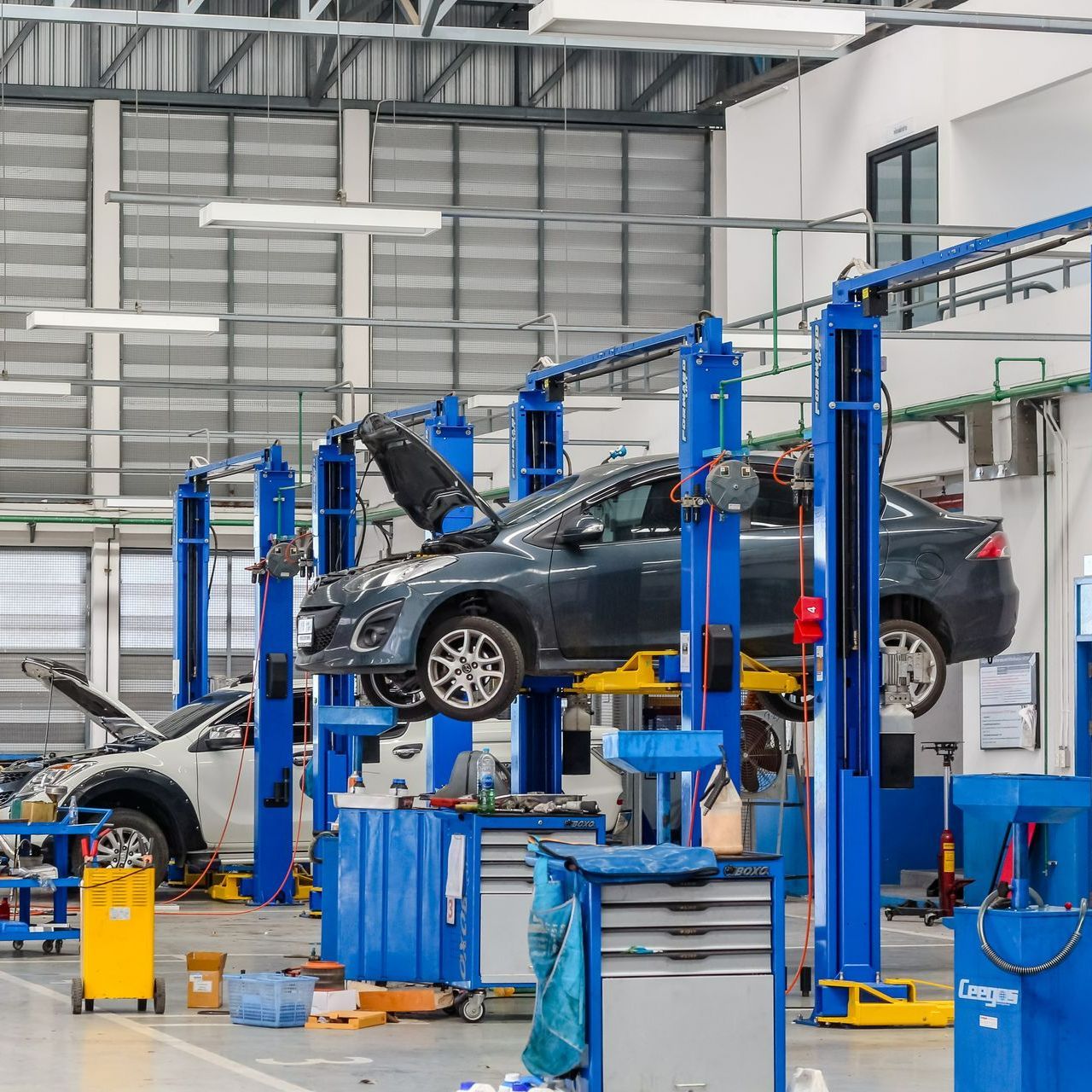 Voiture avec le capot ouvert, surélevé par une machine