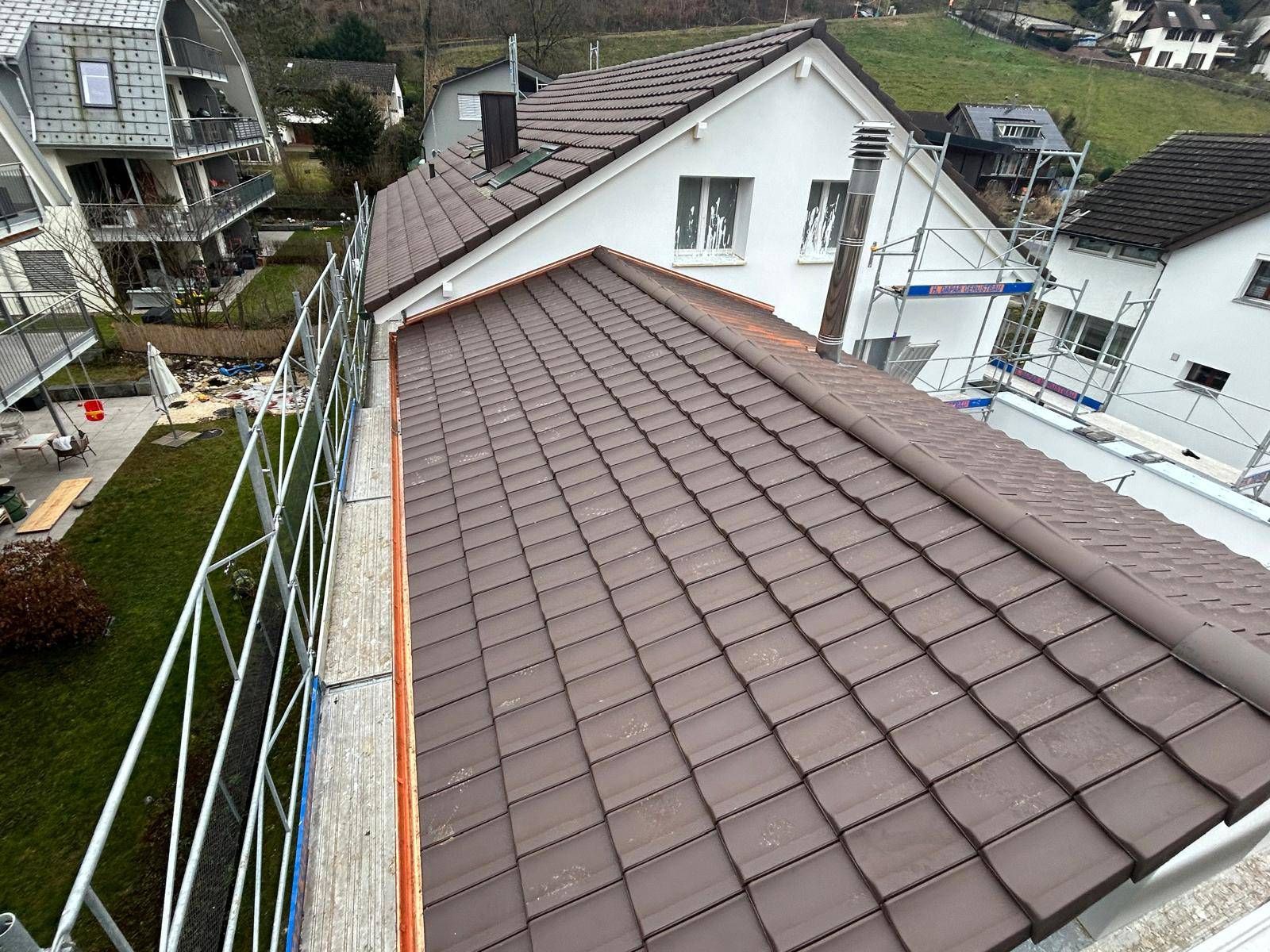 Eine Luftaufnahme eines Hauses mit einem braunen Ziegeldach. Foto von Besi's Dachservice