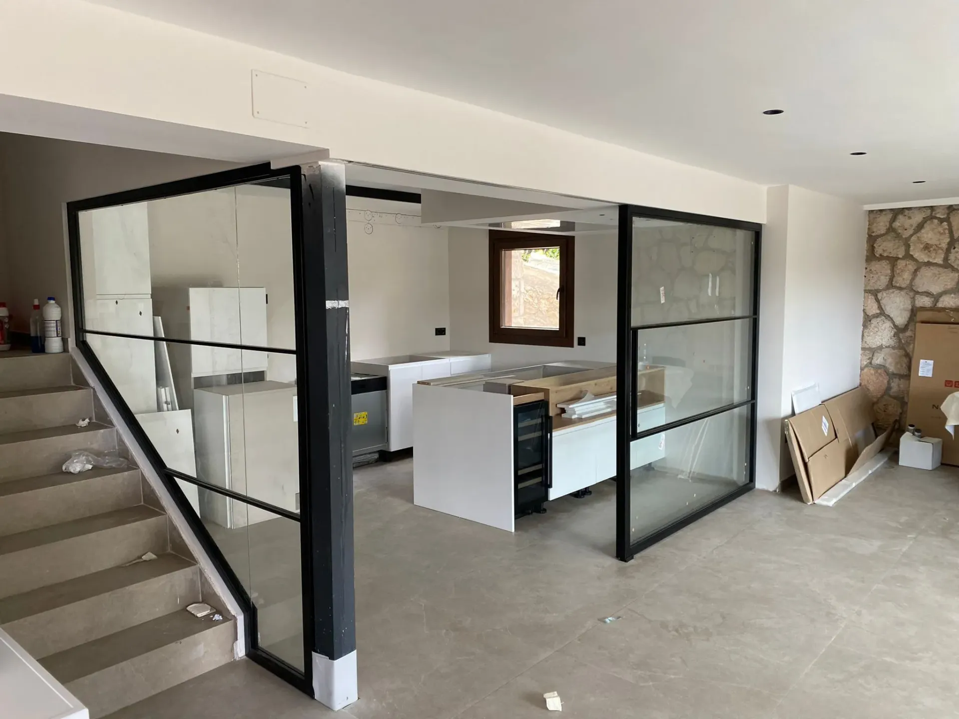 Una habitación con una escalera y una pared de cristal.