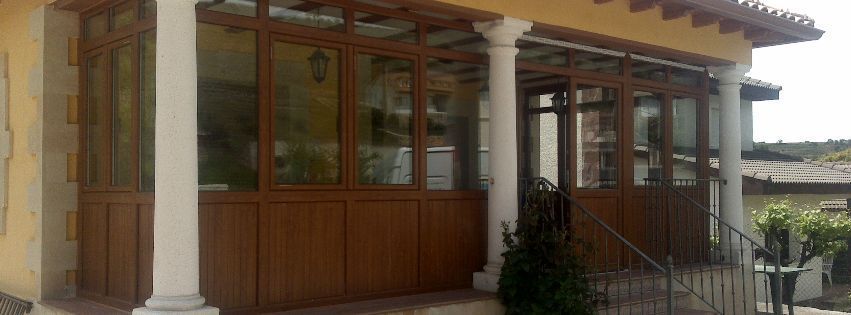 Una casa con porche y muchas ventanas