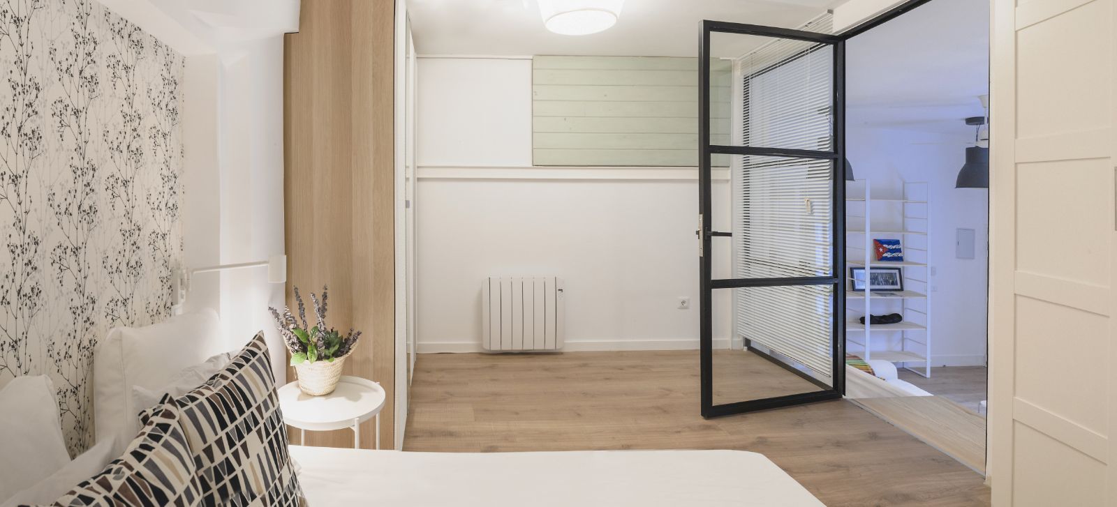 Un dormitorio con una puerta corrediza de vidrio que conduce a un baño.