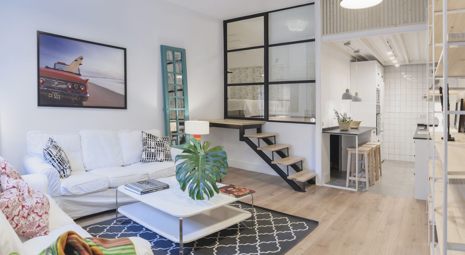 Una sala de estar con un sofá, una mesa de café y escaleras.