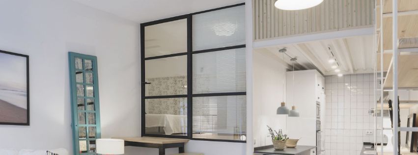 Una sala de estar con muchas ventanas y una mesa y sillas.