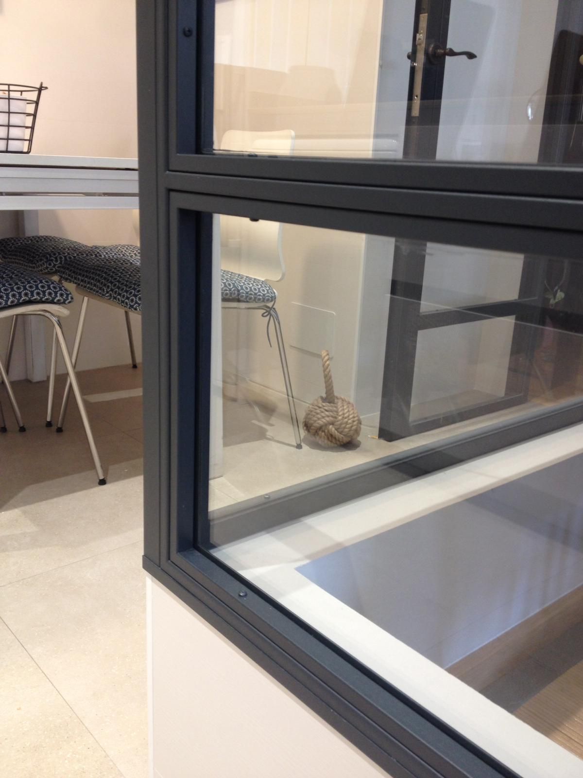 Una habitación con una mesa y sillas y una ventana.