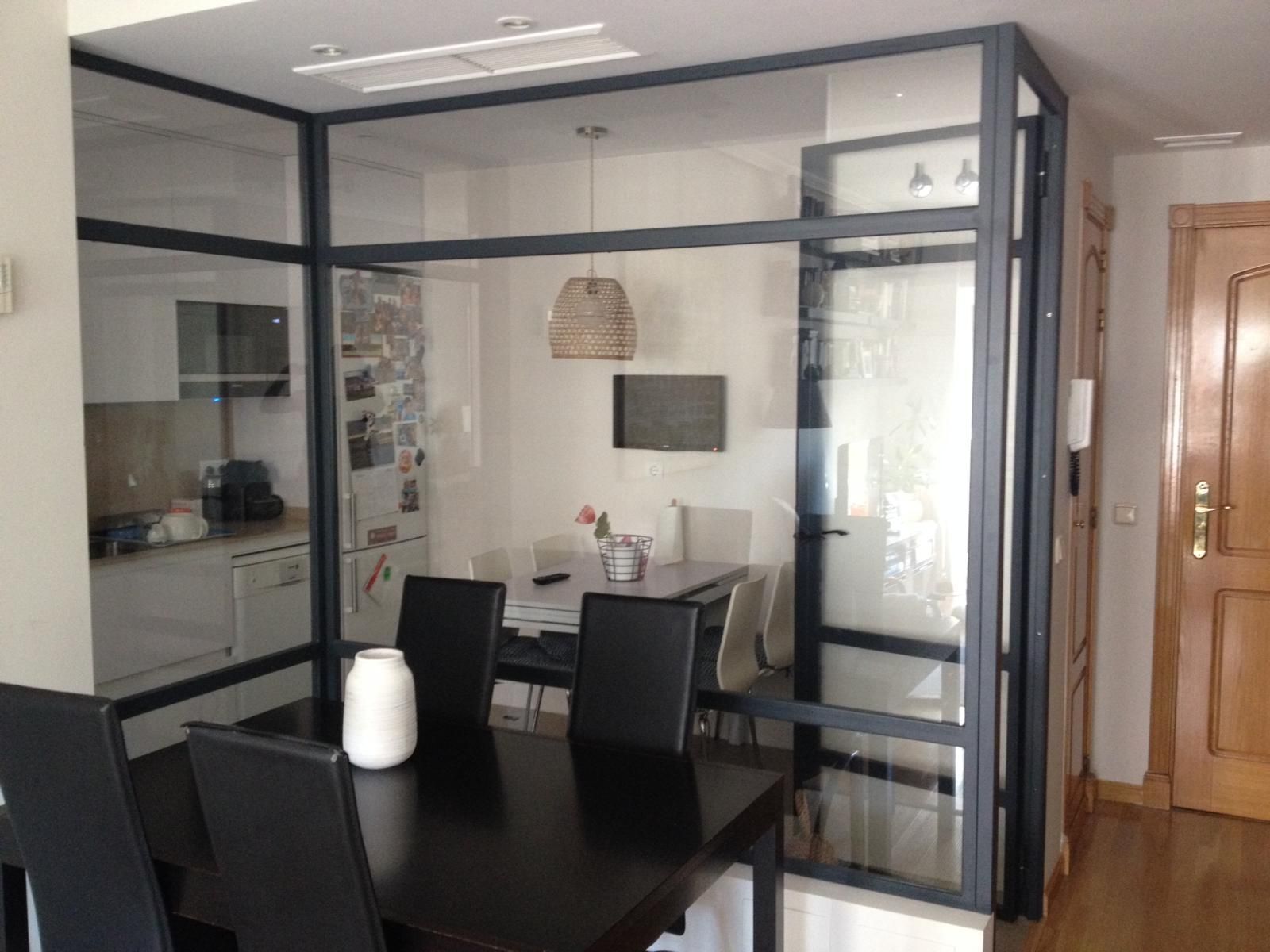 Un comedor con mesa y sillas y una pared de cristal.