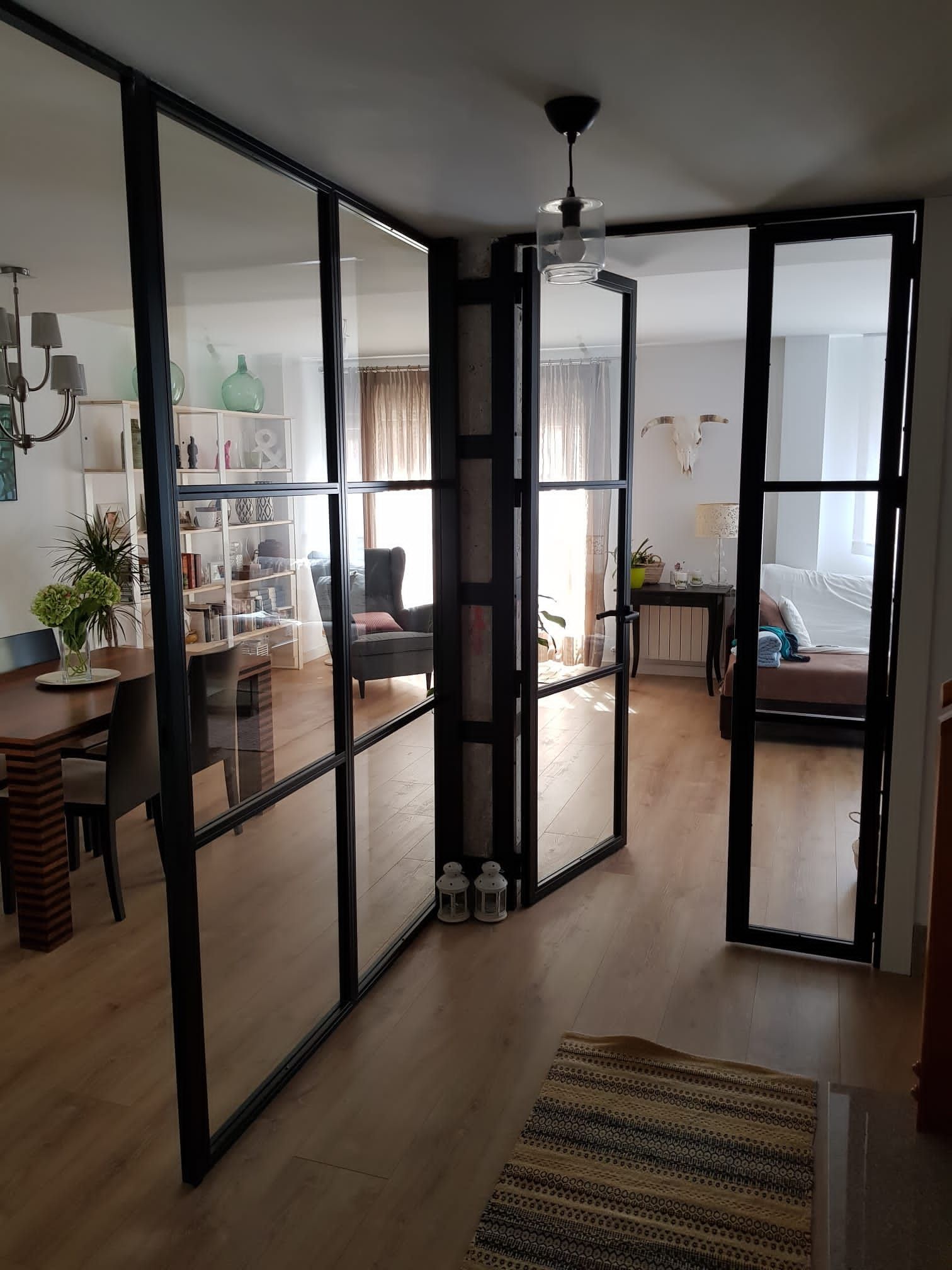 Una sala de estar con una mesa de comedor, sillas y una alfombra.