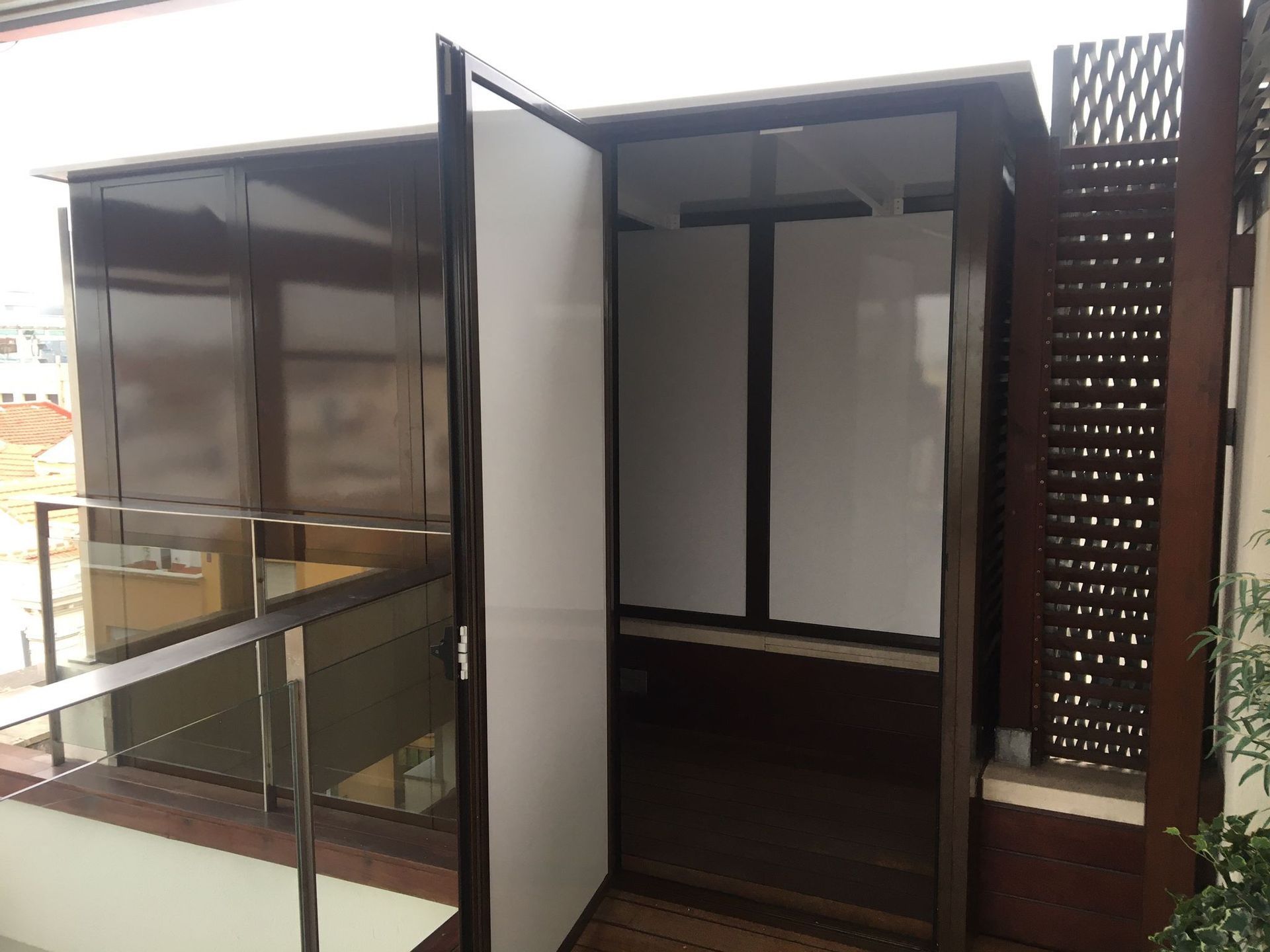 Una habitación con balcón y una puerta que está abierta.