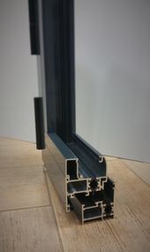 Un primer plano de un marco de ventana sobre un piso de madera.