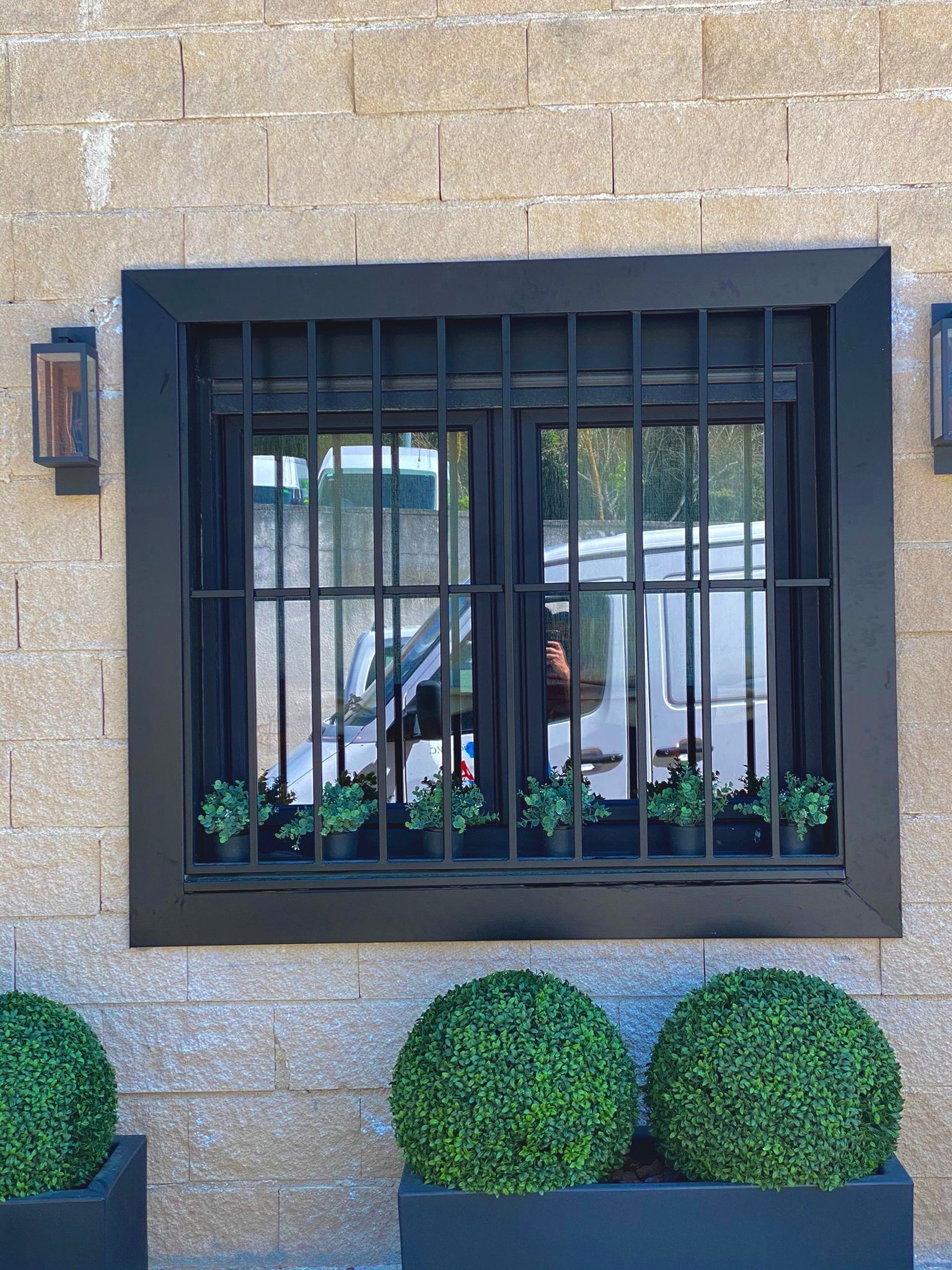 Una ventana con un marco negro y una pared de ladrillos detrás de ella.